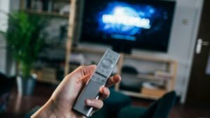Person holding a TV remote control